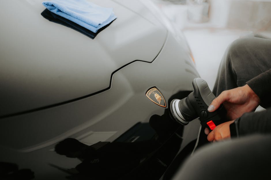 Smiling car detailer polishing a vehicle